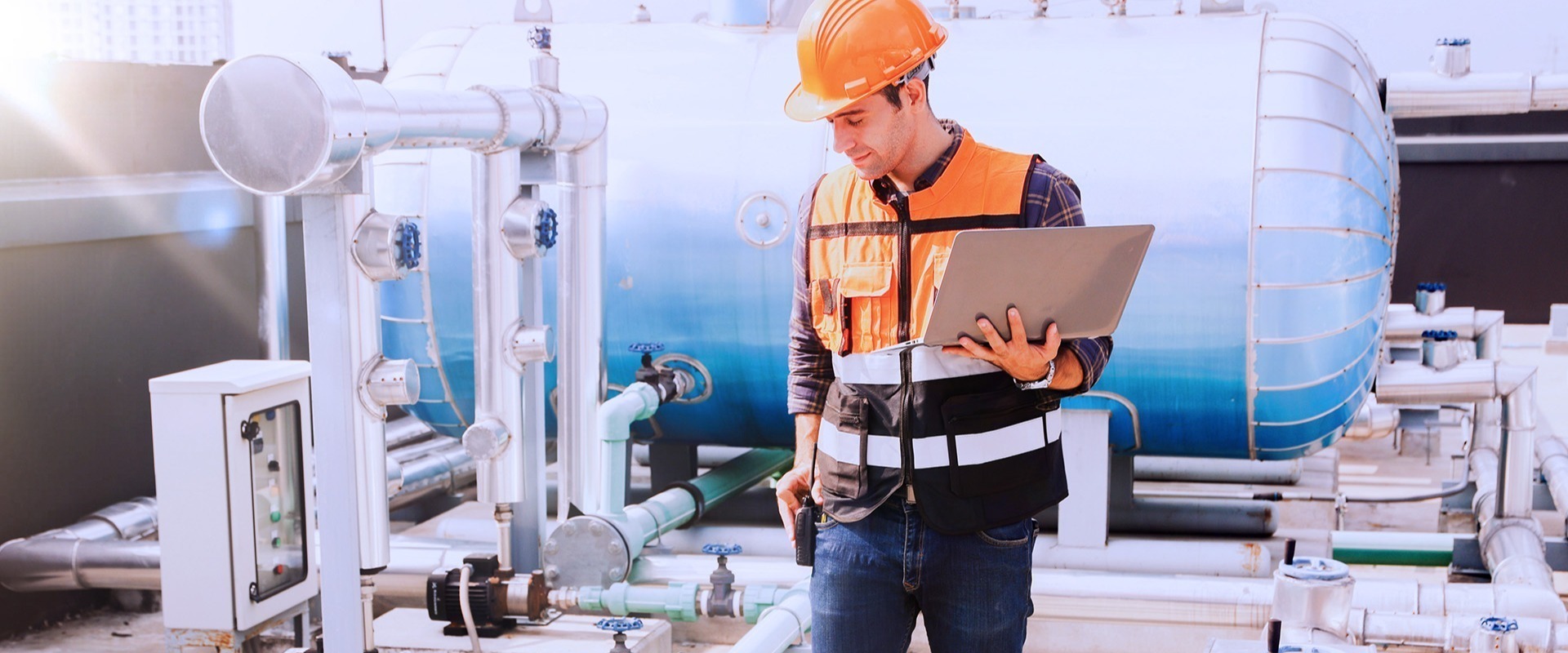 HVAC-technician-with-laptop-on-roof-of-building-1 HVAC-technician-with-laptop-on-roof-of-building-1